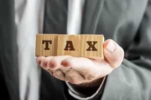 Businessman Holding Blocks with TAX Word