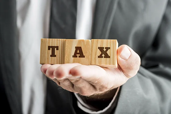 Businessman Holding Blocks with TAX Word