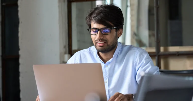 Young professional concentrating on a computer screen in workspace, representing CPA Exam blogger philip gearing regulation