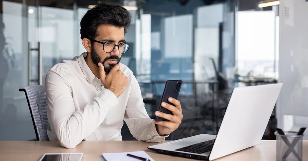 Focused young professional studying with a laptop and smartphone in a office, symbolizing cpa exam tips I used pass far bec and reg