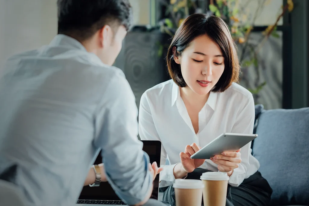 Two professionals conducting business in an open office setting.