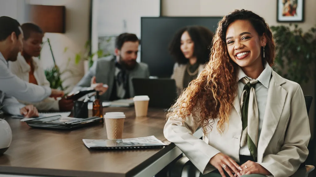 UWorld Accounting exam candidate smiling at a conference table among colleagues preparing for CPA licensure