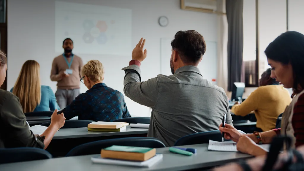 Accounting student raising his hand in a university classroom