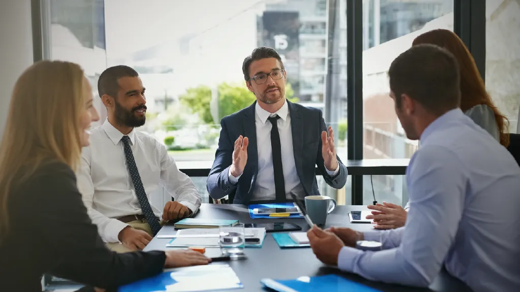 Firm employees working together to solve a problem around a conference table