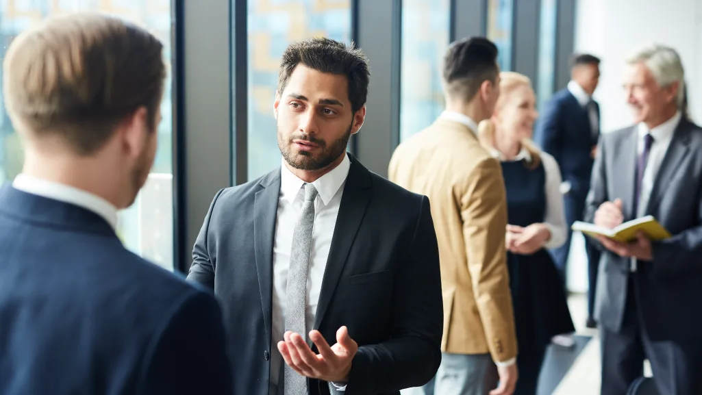 Society members mingling in hallway after a meeting