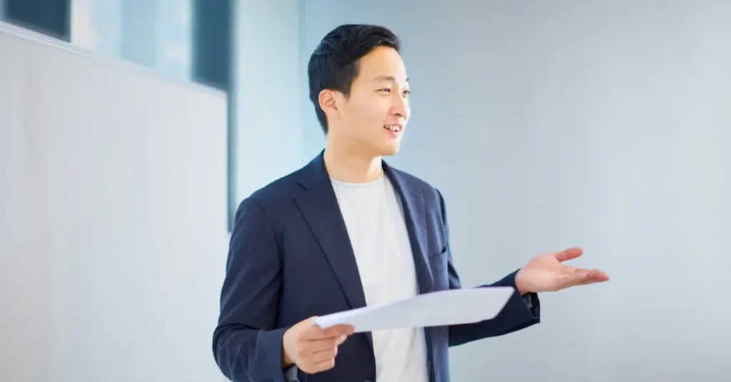 Young business professional presenting in front of white board