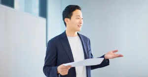 Young business professional presenting in front of white board