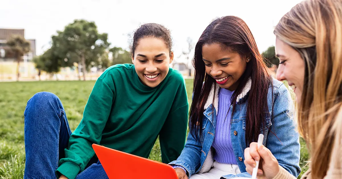 Three students are preparing together to pass the CPA exam on their first attempt, studying with a laptop and taking notes.