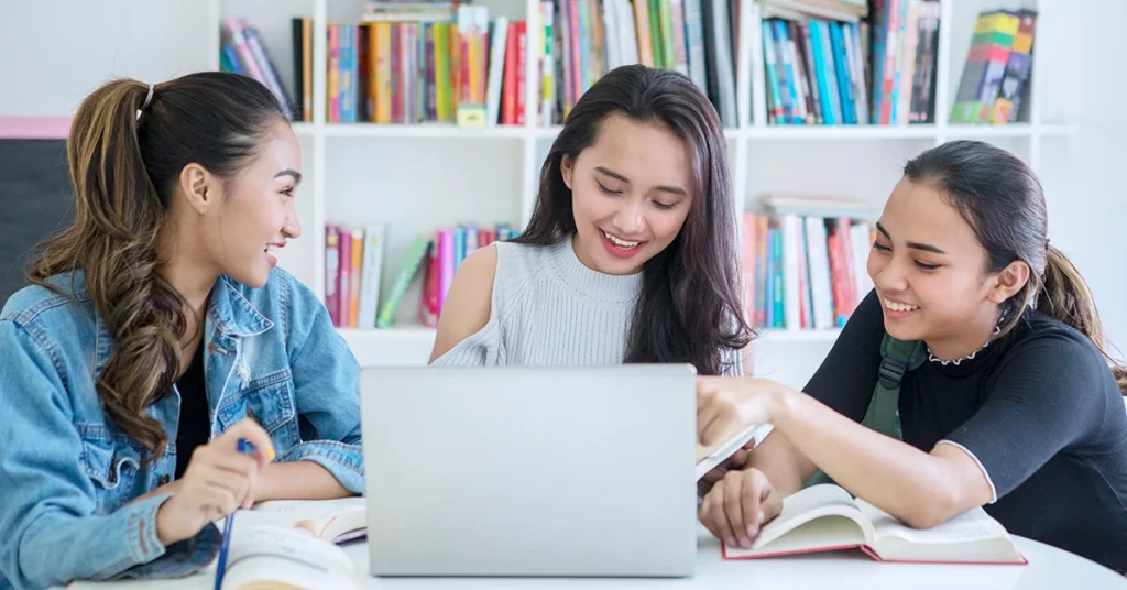 International students studying together with books and a laptop, preparing for the Best CPA Review Course designed for global candidates